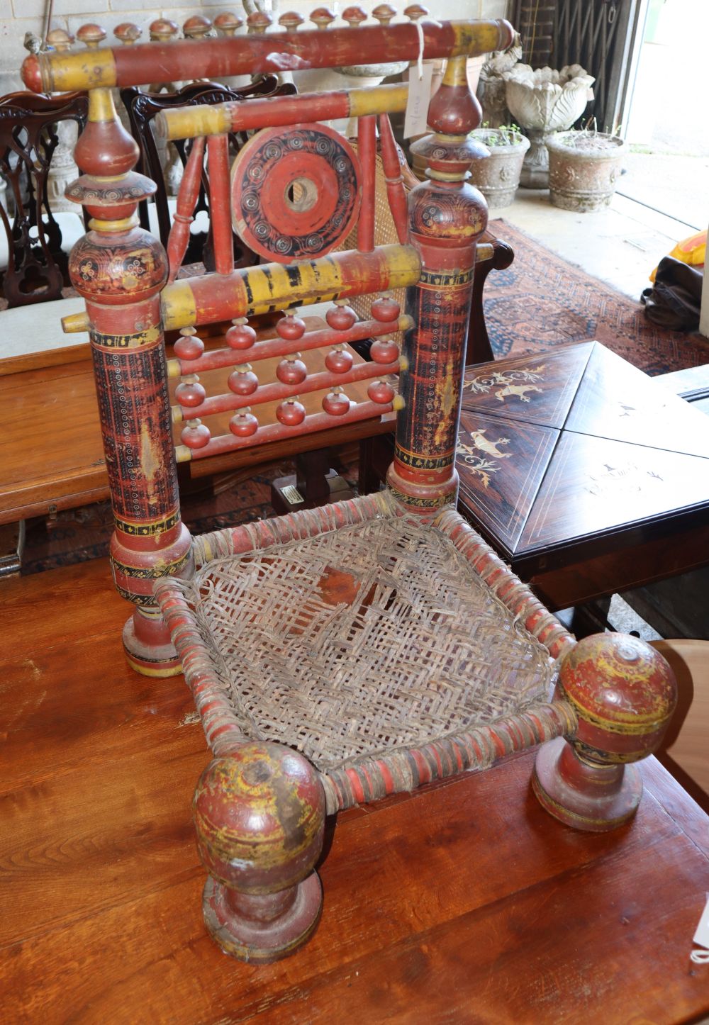 A painted carved Indian low seat chair, W.48cm, D.48cm, H.76cm